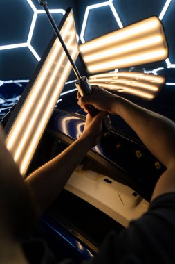 PDR araba göçüğü temizleme, yapıştırıcı çekici ve yansıtma tahtası kullanarak. Araç gövdesindeki yüzeysel kusurları gidermek için özel aletler. Arabanın çatısında çekiçle acısız bir çukur açılır.