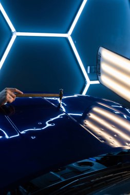 Devrilmiş bir aletle kontrol edilen musluklar dolu tarafından bükülmüş metali yeniden şekillendirir. PDR teknisyeni, çarpma aletini ve çekiç kombinasyonunu dolu izlerini düzeltmek için kullanır. Odaklı vuruşlar boyaya zarar vermeden metali yeniden hizala