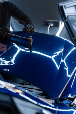 Devrilmiş bir aletle kontrol edilen musluklar dolu tarafından bükülmüş metali yeniden şekillendirir. PDR teknisyeni, çarpma aletini ve çekiç kombinasyonunu dolu izlerini düzeltmek için kullanır. Odaklı vuruşlar boyaya zarar vermeden metali yeniden hizala