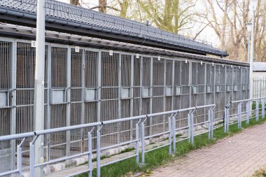Hayvan barınaklarının dış görünüşü birden fazla metal kafes gösteriyor. Köpek barınağı, köpek kulübeleri ve çitleri var. Sokak köpekleri ve kurtarma köpekleri için kafesli hayvan barınağı