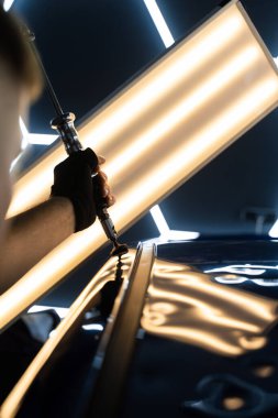 Uzman, metali yeniden boyanmadan eski haline getirmek için ileri çekiş aracı kullanıyor. PDR için parlak bir arabanın çatısında çekme aracı kullanmak, basıncı tam olarak ayarlamak