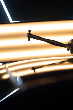 PDR Acısız araba göçüğü temizleme. PDR teknisyeni, kaputtaki çukur düzeltmesini kontrol etmek için yansıma lambasına özel bir çekiç tutuyor.