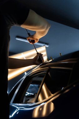 PDR araba göçüğü temizleme, yapıştırıcı çekici ve yansıtma tahtası kullanarak. Araç gövdesindeki yüzeysel kusurları gidermek için özel aletler. Arabanın çatısında çekiçle acısız bir çukur açılır.