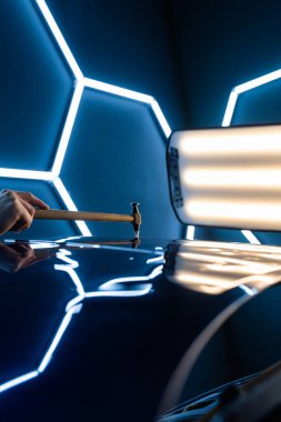 Devrilmiş bir aletle kontrol edilen musluklar dolu tarafından bükülmüş metali yeniden şekillendirir. PDR teknisyeni, çarpma aletini ve çekiç kombinasyonunu dolu izlerini düzeltmek için kullanır. Odaklı vuruşlar boyaya zarar vermeden metali yeniden hizala