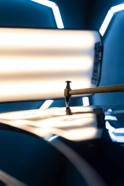 Devrilmiş bir aletle kontrol edilen musluklar dolu tarafından bükülmüş metali yeniden şekillendirir. PDR teknisyeni, çarpma aletini ve çekiç kombinasyonunu dolu izlerini düzeltmek için kullanır. Odaklı vuruşlar boyaya zarar vermeden metali yeniden hizala