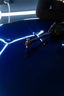 Devrilmiş bir aletle kontrol edilen musluklar dolu tarafından bükülmüş metali yeniden şekillendirir. PDR teknisyeni, çarpma aletini ve çekiç kombinasyonunu dolu izlerini düzeltmek için kullanır. Odaklı vuruşlar boyaya zarar vermeden metali yeniden hizala