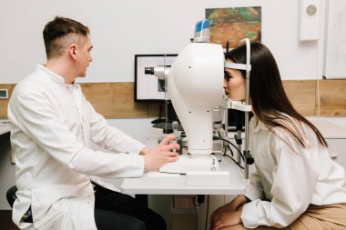 Korneanın şekli ve gücünün görsel tanımı için kornea topografisi göz görme testi. Kornea topografının kırmızı ışığı topoğrafya sınavında kadının üzerine parlıyor