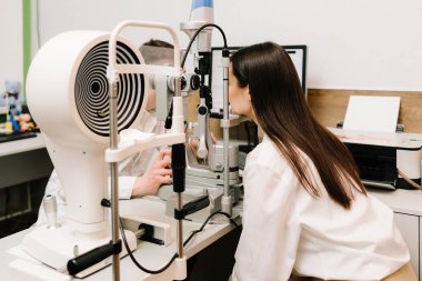 Göz ve kornea kontrolü için kesik lamba ile oftalmoloji prosedürü. Kız göz muayenesi için göz doktorunu ziyaret ediyor.