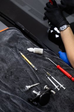 İş yüzeyinde otomobil ön camı tamir aletleri. Ön camı tamir etmek için gerekli aletler düzgün düzenlenmiş ve profesyonel çip restorasyonu için hazır.