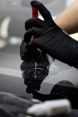 Awl bir ön cam çatlağının kenarına yerleştirilir. Teftiş ya da çip hazırlığı için. Teknisyen cam bir çip üzerinde kontrollü basınç uygulamak için metal bir alet kullanıyor.