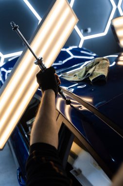 PDR için parlak bir arabanın çatısında çekme aleti kullanmak, basıncı tam olarak ayarlamak. Uzman, metali yeniden boyanmadan eski haline getirmek için ileri çekiş aracı kullanıyor