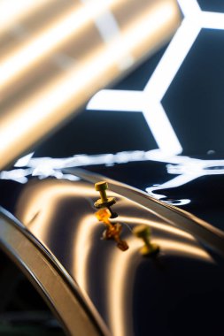 Ağrısız çukur onarma işlemi sırasında LED ışıklarının altındaki çökmüş bir arabanın çatısına birden fazla yapıştırıcı şeridi takılmış. Yapıştırıcı sekmeleri yüzeyi hatasız bir bitiş için hizalamaya ve onarmaya yardımcı olur