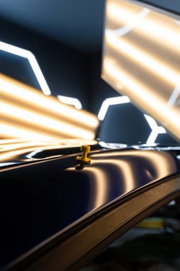 Hassas ve acısız bir tamir seansı sırasında araba yüzeyine yapıştırıcı sürmüş. Yüksek yansıma aydınlatması kusursuz araba göçüğü temizleme için görünürlüğü artırır