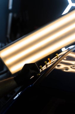 Yapıştırıcı sekmeleri yüzeyi kusursuz bir bitiş için hizalamaya ve onarmaya yardımcı olur. Ağrısız çukur onarım işlemi sırasında LED ışıkları altında çökmüş bir arabanın çatısına çoklu yapıştırıcı sekmeleri uygulanır