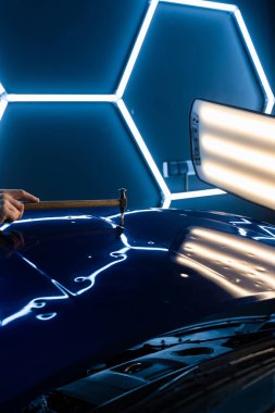 PDR teknisyeni, çarpma aletini ve çekiç kombinasyonunu dolu izlerini düzeltmek için kullanır. Odaklanmış vuruşlar boyaya zarar vermeden metali yeniden hizaladı. Devrilmiş bir aletle kontrol edilen musluklar dolu ile bükülmüş metali yeniden şekillendirir