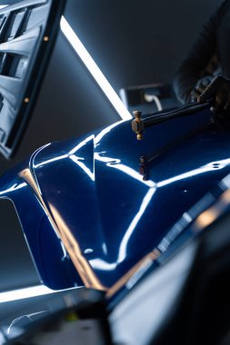 Devrilmiş bir aletle kontrol edilen musluklar dolu tarafından bükülmüş metali yeniden şekillendirir. PDR teknisyeni, çarpma aletini ve çekiç kombinasyonunu dolu izlerini düzeltmek için kullanır. Odaklı vuruşlar boyaya zarar vermeden metali yeniden hizala