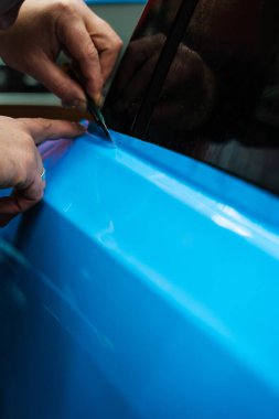 Keskin bıçaklı PPF budama. Vinil ambalaj detaylarında bıçak budamak mükemmellik için çok önemlidir. Keskin bıçak detaylandırma sürecini sonuçlandırmak için kullanılır, PPF paketini tam hassasiyetle keser