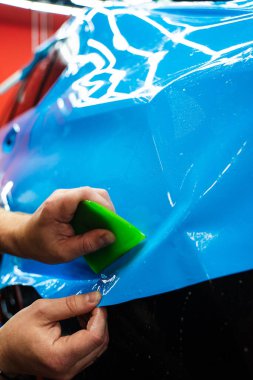 Yeşil bir cam sileceği kullanarak yüksek parlak mavi bir PPF uygulamak, arabanın baloncuksuz ve pürüzsüz bir yüzeyi olmasını sağlar. Mavi PPF yeşil cam sileceği ile uygulanan ayrıntılı araba bitiş ve hasar önlemek için