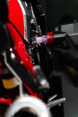 Motosiklet yağı doldur. En iyi performansı ve motor ömrünü uzatmak için motor yağını spor motosikletine yerleştirmek. Uygun motor yağını sağlamak için kırmızı bir spor bisikleti üzerinde hassas yağ doldurma işlemi