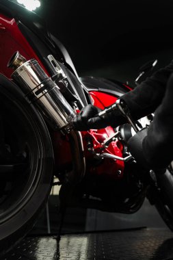 Motor krom egzoz sistemindeki mekanik sıkıştırma cıvataları en yüksek performans için. Kırmızı motorsiklette özel egzoz kurulumu sürüş performansını artırır. Egzoz Motoru Sistem Bakımı