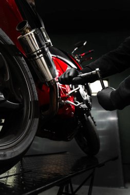 Egzoz Motorsiklet Sistemi Bakımı. Motor krom egzoz sistemindeki mekanik sıkıştırma cıvataları en yüksek performans için. Kırmızı motosiklette özel egzoz kurulumu sürüş performansını artırır