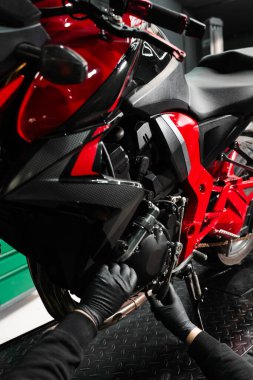 Tamirci, tam bakım sırasında motorsiklet krank üzerinde çalışıyor. Mandal anahtarı ile motosiklet krank denetimi performans verimliliğini sağlar