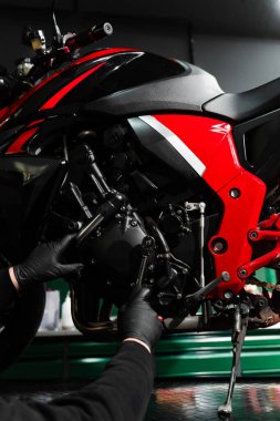 Mandal anahtarlı motorsiklet krank denetimi performans verimliliğini sağlar. Tamirci tam bakım denetimi sırasında motorsiklet krank üzerinde çalışıyor.