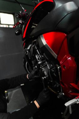 Tamirci, tam bakım sırasında motorsiklet krank üzerinde çalışıyor. Mandal anahtarı ile motosiklet krank denetimi performans verimliliğini sağlar