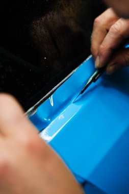 Keskin bıçaklı PPF budama. Vinil ambalaj detaylarında bıçak budamak mükemmellik için çok önemlidir. Keskin bıçak detaylandırma sürecini sonuçlandırmak için kullanılır, PPF paketini tam hassasiyetle keser
