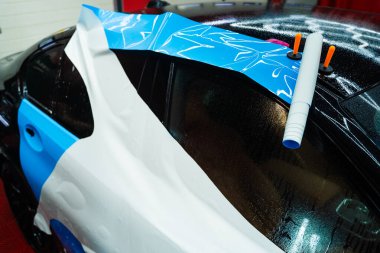 Detaylar Merkezi 'nde Islak PPF Uygulaması. Boya koruma filminin ıslak uygulaması hava kabarcıklarını önler ve mükemmel bir uyum için ayarlamaya izin verir