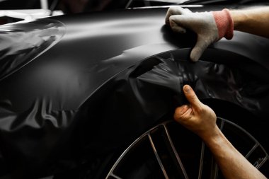 Arabanın etrafına kıvrımları ve kenarları pürüzsüz bir şekilde siyah vinil sarılmış. Lüks aracın ön çamurluk ve tekerlek kemerine siyah vinil ambalaj uygulaması. Arabanın Vinil Paketi