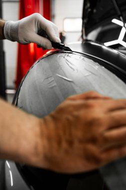 Plakları sarmak için mükemmel gerilim ve kaliteli detaylar için keskin bıçaklar gerekir. Plastik film, kusursuz araç ambalaj sonuçları için dikkatlice uygulanır ve bıçakla budanır.