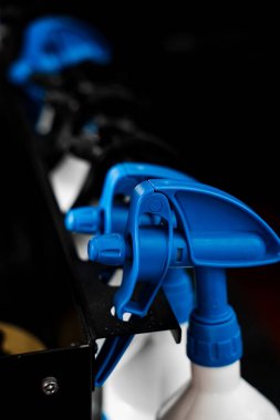 Araba Bakımı Ürünleriyle Sprey Şişe Detaylandırması. Otomotiv temizleme sıvılarıyla dolu sıra sprey şişeleri kullanıma hazır. Spreyler birden fazla detaylı kimyasallar içerir.