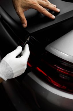 Mükemmel uyum ve temiz görsel sonuçlar için el yapımı vinil kesim. Vinil Uygulaması Detaylandırılıyor. Vinil film, boşluklar ve yırtıklar olmadan pürüzsüz kenarlar sağlamak için keskin bıçakla kesilir.