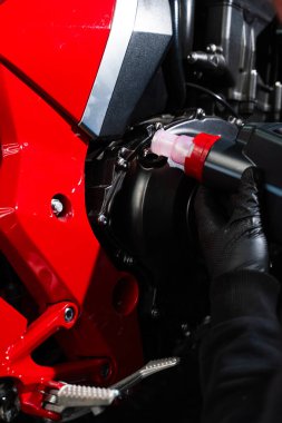 Motosiklet yağı doldur. En iyi performansı ve motor ömrünü uzatmak için motor yağını spor motosikletine yerleştirmek. Uygun motor yağını sağlamak için kırmızı bir spor bisikleti üzerinde hassas yağ doldurma işlemi