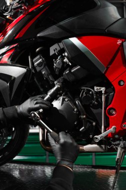 Tamirci, tam bakım sırasında motorsiklet krank üzerinde çalışıyor. Mandal anahtarı ile motosiklet krank denetimi performans verimliliğini sağlar