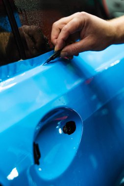 Keskin bıçak detaylandırma sürecini sonuçlandırmak için kullanılır, PPF ambalajını kesin bir hassasiyetle keser. Keskin bıçaklı PPF budama. Vinil ambalaj detaylarında bıçak budamak mükemmellik için çok önemlidir