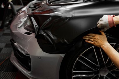 Arabanın etrafına kıvrımları ve kenarları pürüzsüz bir şekilde siyah vinil sarılmış. Lüks aracın ön çamurluk ve tekerlek kemerine siyah vinil ambalaj uygulaması. Arabanın Vinil Paketi