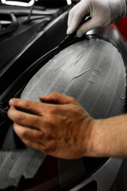 Plakları sarmak için mükemmel gerilim ve kaliteli detaylar için keskin bıçaklar gerekir. Plastik film, kusursuz araç ambalaj sonuçları için dikkatlice uygulanır ve bıçakla budanır.