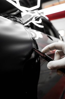 Tam panelli araba plastiği paketleme. Büyük ölçekli vinil ambalaj kurulumu aracın dış yüzeyini mat siyah filmle dönüştürür. Araba sarma uygulaması araç görünümünü değiştirir