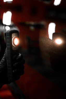 Detaylı bir stüdyoda siyah arabadaki boya sorunlarını tespit etmek için girdap bulucu ışık. Araba boyası denetimi. Araba boyası denetimi cilalama veya seramik kaplamadan önce ayrıntılı denetim ışığı kullanır