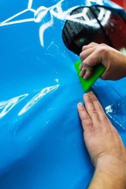 Yeşil bir cam sileceği kullanarak yüksek parlak mavi bir PPF uygulamak, arabanın baloncuksuz ve pürüzsüz bir yüzeyi olmasını sağlar. Mavi PPF yeşil cam sileceği ile uygulanan ayrıntılı araba bitiş ve hasar önlemek için