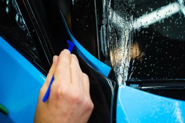 Micro Squeegee Trim Wrap 'te. Mikro cam sileceği, araba ambalajı kurulumu sırasında dikişsiz yapışmayı sağlar. Dar araç süsleme aralıklarının derinliklerine mavi vinil sargıya basmak için mikro ekleme aracı