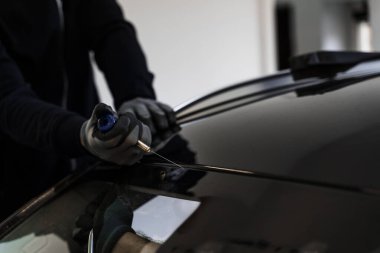 Arabanın ön camını değiştirme işlemi. Ön cam kaldırma işlemi özel kesme kablosu ve kazıma aracı kullanılarak yapılıyor. Otomobil teknisyeni ön camı ince tel ve kazıma bıçağı kullanarak ayırıyor.