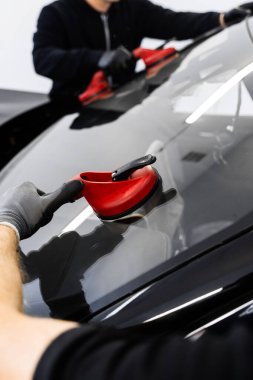 Yeni ön cam kurulum süreci. Aspirasyon asansörlerini kullanarak ön cam kurulumu. İki teknisyen vantilatör kullanarak ön cam kuruyor. Ön cam yerleştirme güvenli bir mühür ve bütünlük sağlar