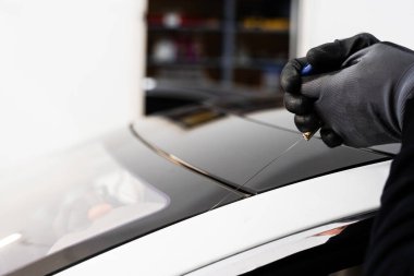 Ön cam kaldırma işlemi özel kesme kablosu ve kazıma aracı kullanılarak yapılıyor. Otomobil teknisyeni ön camı ince tel ve kazıma bıçağı kullanarak ayırıyor. Arabanın ön camını değiştirme işlemi