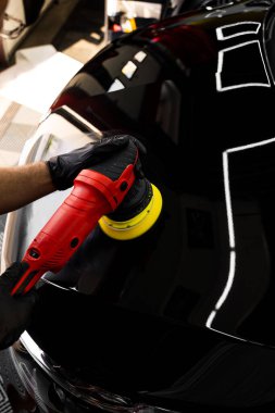 Boya cilası aktif hareket halinde. Mühürleyici ya da seramik uygulama için araba detaylandırılıyor. Girdap izlerini silmek ve derin parlatıcıyı geri getirmek için boya parlatıcısı. Araba kaputu sarı bloknotla parlatılıyor.