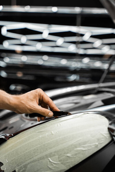 Виниловая пленка тщательно наносится и обрезается лезвием для безупречных результатов упаковки автомобиля. Упаковка винила требует идеального натяжения и точной работы лезвия для высокого класса детализации