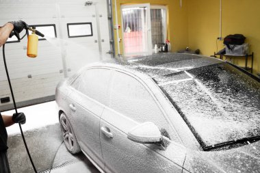 Araba Köpürtme Sahnesi. Yüksek basınçlı kar köpüğü uygulaması derin bir temizlik sağlar ve araba yüzeyindeki kiri yumuşatır. Araba ilk yıkama aşamasında yoğun kar köpüğüyle kaplanır.