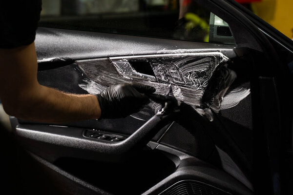Interior Door Panel Brushing and deep clean fabric and plastic using foam agitation. Interior detailing includes scrubbing textured door panels with cleaning agents to remove embedded dust and grime.